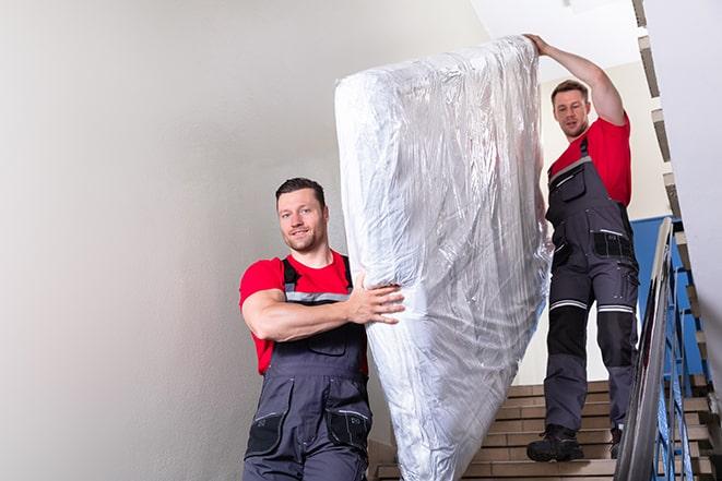 team of workers maneuvering a box spring through a doorway in San Luis AZ